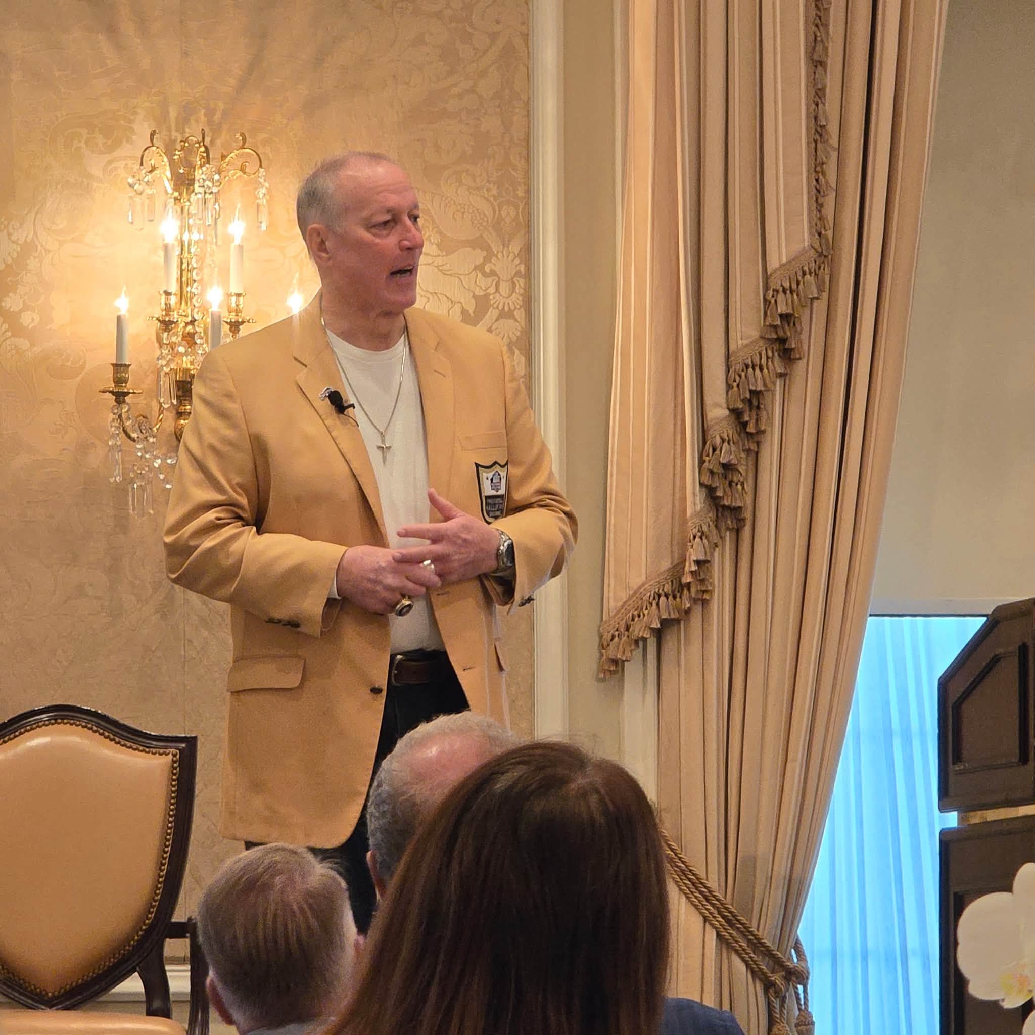 Jim Kelly speaking at the club’s charity breakfast, shared September 23, 2026
